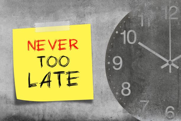 Never too late. Never too late message on post-it with clock Never too late. Never too late message on post-it with clock